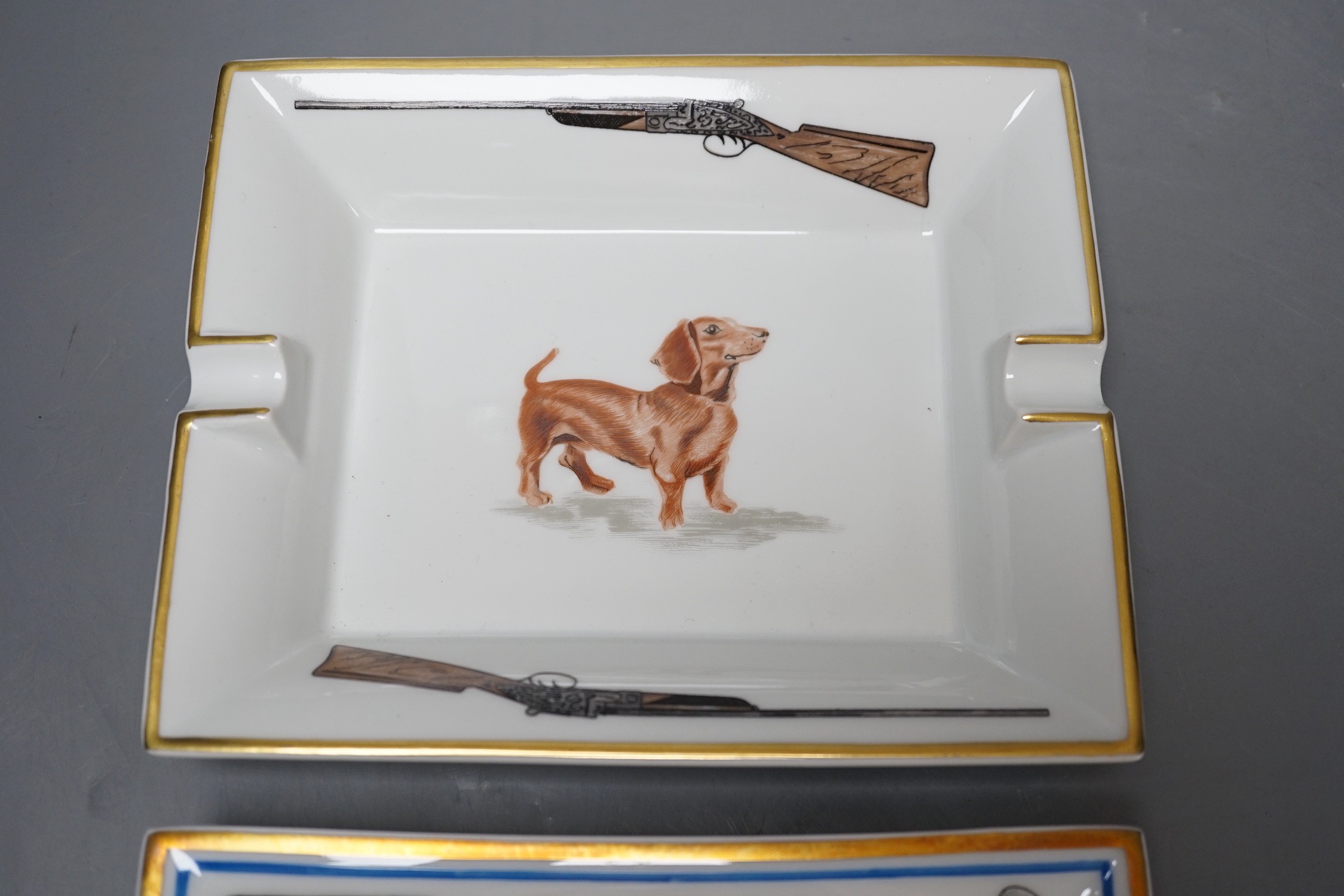 Two Hermes, Paris porcelain ashtrays: one golfing related (boxed), the other hunting related, golf ashtray 19 cms x 15 cms